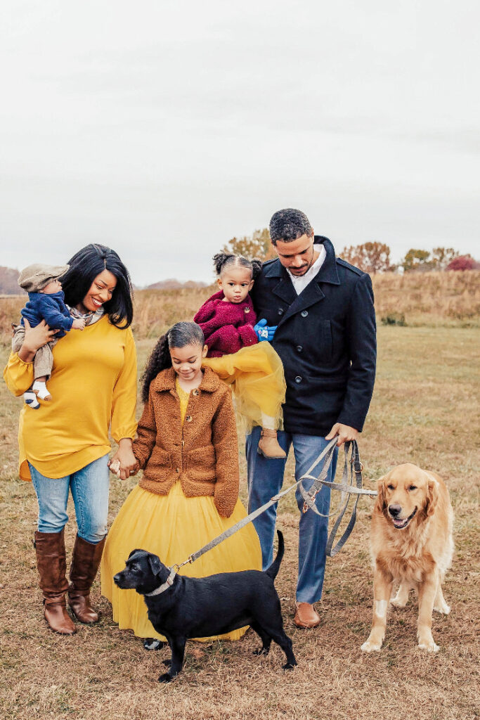 Victoria Vaden and her family, including three kids and husband, enjoying a beautiful fall day at the park with their Golden Retriever and small black dog